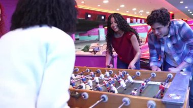 Genç yetişkinler bowling salonunda rekabetçi bir şekilde langırt oynuyorlar, dinamik yavaş çekim, hafta sonu boş zamanlarında enerjik dostluk ve neşeyi gözler önüne seriyor.