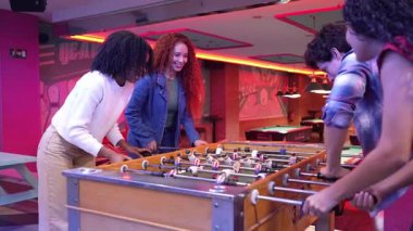 Bir grup arkadaş bir bowling salonunda ağır çekimde langırt oynuyorlar ve bir golü beşlikle kutluyorlar.