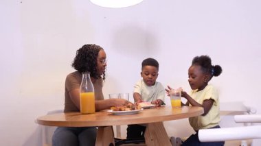 Anne ile birlikte kahvaltı hazırlamak, sıcak sohbet ve iletişimi paylaşmak ve sıcak mutfak ortamında birlikte besleyici bir sabah yemeği yemek.