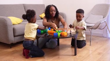 Sevecen ebeveynler ve çocuklar birlikte renkli bloklar inşa ediyorlar, kahkahalar ve yaratıcılığı paylaşıyorlar, aile bağlarını sıcak oturma odasında güçlendiriyorlar.