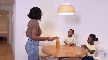 Afrikalı Amerikalı aile üyeleri renkli yapı taşlarıyla oynarken yakınlaşıyorlar, rahat oturma odası ortamında yaratıcı öğrenme aktiviteleriyle uğraşıyorlar.