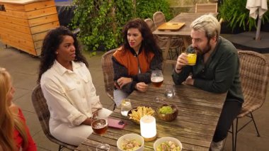 Arkadaşlar iyi vakit geçirir, canlı sohbetler eder ve çatı katındaki bir barda içki ve atıştırmalıkların keyfini çıkarırlar.