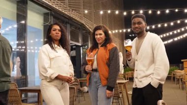 Çeşitli arkadaşlar çatı partisinden zevk alıyor, kokteylleri paylaşıyor, canlı şehir hayatı arka planıyla canlı sohbetler yapıyor.