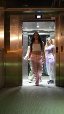 Asansörden inen ve geceleri köprüde dans eden genç kadın dansçılar.