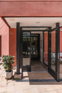 Cam kapılar açık duruyor, ziyaretçileri çağdaş bir huzurevine davet ediyor, ulaşılabilirliği ve sıcak, misafirperver bir atmosferi vurguluyor.