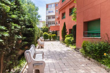 Huzurlu banklar huzur ve refahı teşvik eden bir huzurevinin bahçesindeki yemyeşil yemyeşil ortamda huzurlu bir dinlenme yeri sağlar.