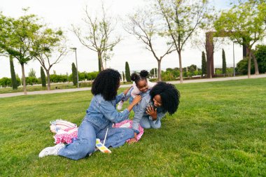 İki ikiz kardeş güneşli bir günün tadını çıkarıyorlar. Yeğenleriyle neşeyle oynuyorlar yemyeşil çimlerin üzerinde.