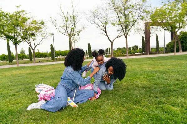 İki ikiz kardeş güneşli bir günün tadını çıkarıyorlar. Yeğenleriyle neşeyle oynuyorlar yemyeşil çimlerin üzerinde.