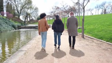 Arkadaşlar birlikte sahil yolunda yürüyorlar, güneşli bahar gününün tadını yavaş çekimde çıkarıyorlar, arkadaşlığın ve beraberliğin kaygısız anlarını arkadan yakalıyorlar.