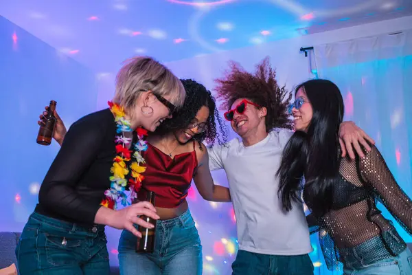 Dört neşeli çoklu etnik arkadaş eğleniyor, bira içiyor ve renkli disko ışıkları altında canlı bir ev partisinde dans ediyorlar.