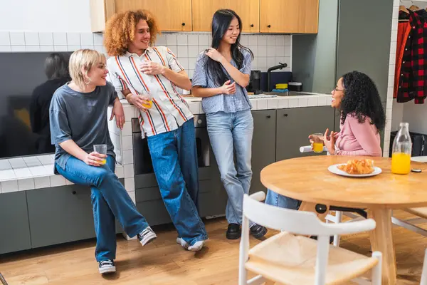 Çağdaş bir mutfakta dört farklı arkadaş kahvaltı ediyor ve canlı sohbetler yapıyorlar. Sıcak ve sosyal bir ortam yaratıyorlar.