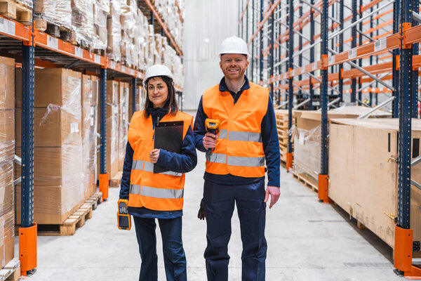 Warehouse workers are checking inventory using barcode scanner and clipboard, ensuring efficient logistics and order fulfillment