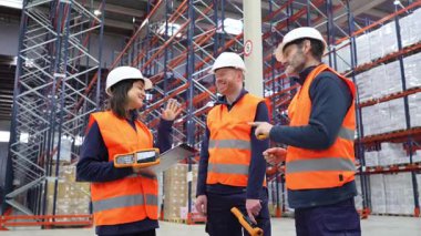 Depo çalışanları lojistik ve envanter yönetimini tartışıyor, dağıtım merkezinde verimliliği ve takım çalışmasını geliştiriyor