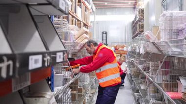 Depo çalışanı, barkod okuyucusuyla raflardaki paketleri tarıyor, envanter ve lojistiği yönetiyor.