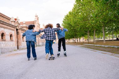Öğleden sonra kaykay ve kaykay yapan bir grup genç arkadaş, özgürlüğü, arkadaşlığı ve şehir yaşam tarzını sembolize ediyor.