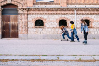 Bir grup arkadaş şehirde kaykay ve paten kayarak, boş zamanlarını ve gençlik yoldaşlıklarını sergileyerek eğleniyorlar.