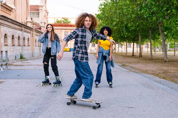 Genç arkadaşlar şehir parkında kaykay ve kaykay yaparak eğleniyorlar. Gençlik enerjisi ve kentsel eğlence aktiviteleri sergiliyorlar.