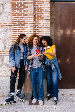 Üç neşeli genç arkadaş bir öğleden sonra kayak seansından sonra akıllı telefondan komik videolar izliyorlar.