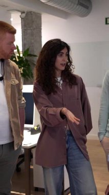 Profesyonel yaratıcı ekip parlak modern çalışma alanında birlikte çalışıyor, yenilikçi fikirleri paylaşıyor ve proje stratejisini işbirlikçi enerjiyle tartışıyor.