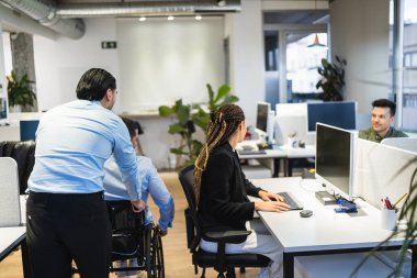 Modern kapsayıcı bir ofiste birlikte çalışan iş arkadaşları ve yöneticiler, işyerlerindeki çeşitlilik ve işbirliğini teşvik ederler.