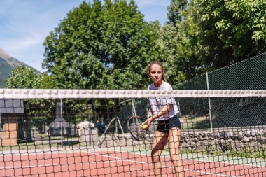 Bir sonraki hamleye konsantre olan sporcu, doğayla çevrili bir kil sahada oynanan tenis maçında...