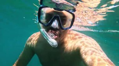Turist güzel sualtı dünyasını keşfeder, kristal berrak turkuaz sularda şnorkelle yüzmekten zevk alır.