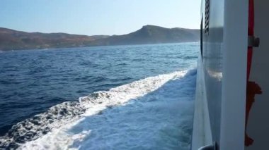 Girona 'da gül kıyılarında yelken açan bir tekneyi takip eden beyaz dalgalar mavi denizle güzel bir kontrast oluşturuyor.