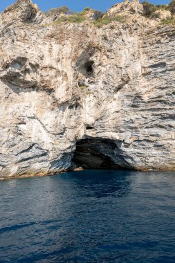 Sakin mavi su, yükselen kayalıklarla ve gizli mağaralarla buluşur. Güller içinde bir tekne gezisi sırasında nefes kesici bir sahil manzarası yaratır.