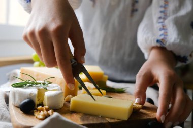 Kadınlar peynir keser ve akşam yemeği hazırlar. Peynir çeşitleri. Geleneksel İsviçre yemekleri gibi fondü. 
