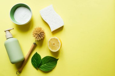 Ahşap fırça, limon, sarı arka planda kabartma tozu. Çevre temizliğinin tazeliği