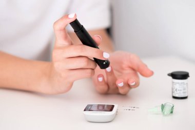 Kan şekeri seviyesini glukometreye göre ölçen bir kadın. Dünya Diyabet Günü. Sağlık sigortası konsepti. Evde kan şekeri seviyesine nasıl bakılır?. 