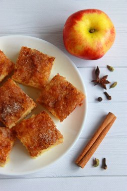 Elmalı tarçınlı kek kareleri tabakta. Karamelli ve baharatlı ev yapımı elmalı kek.