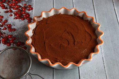 Ev yapımı çikolatalı trüf peynirli kek seramik tavada kakao tozu.