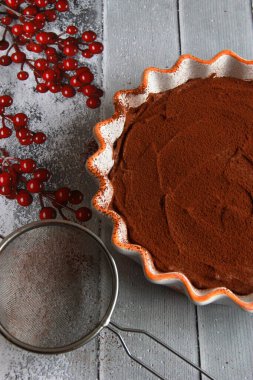 Ev yapımı çikolatalı trüf peynirli kek seramik tavada kakao tozu.