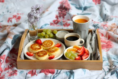 Yatakta kahvaltı - sade kahve, portakal suyu, ekşi krema ve taze meyveli süzme peynirli peynirli kek