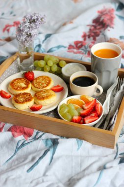 Yatakta kahvaltı - sade kahve, portakal suyu, ekşi krema ve taze meyveli süzme peynirli peynirli kek