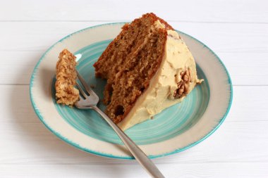 Ceviz yarısıyla süslenmiş kremalı cevizli ve kahveli kek. Tereyağlı ve kremalı ev yapımı vejetaryen pastası.