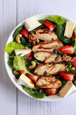 Çilekli tavuk salatası, taze sebze, fındık ve krema. Tavuk fileto, yeşillik, böğürtlen ve peynirli sağlıklı bahar salatası..