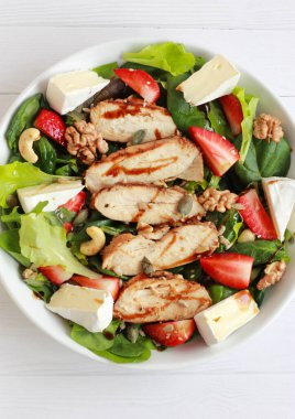 Çilekli tavuk salatası, taze sebze, fındık ve krema. Tavuk fileto, yeşillik, böğürtlen ve peynirli sağlıklı bahar salatası..