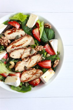Çilekli, fındıklı ve peynirli tavuk salatası. Tavuk fileto, peynir, ıspanak ve cevizli ev yapımı bahar salatası.