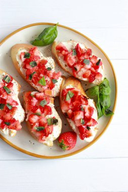 Krem peynir, fesleğen ve balzamik jöleli çilekli bruschetta.