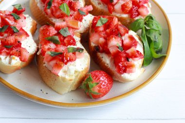 Krem peynir, fesleğen ve balzamik jöleli çilekli bruschetta.