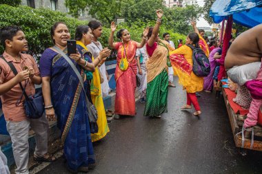 Kimliği belirsiz kişiler dans ediyorlar ve Ikcon Kolkata ratha yatra 2024 sırasında çeşitli aktiviteler yapıyorlar.