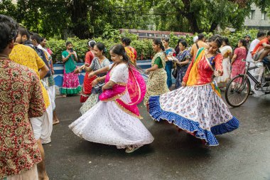 Kimliği belirsiz kişiler dans ediyorlar ve Ikcon Kolkata ratha yatra 2024 sırasında çeşitli aktiviteler yapıyorlar.