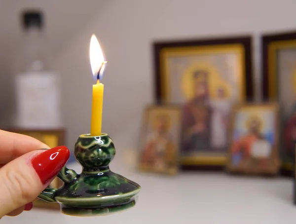 Church candle in green candlestick near icons ,orthodox faith . High quality photo