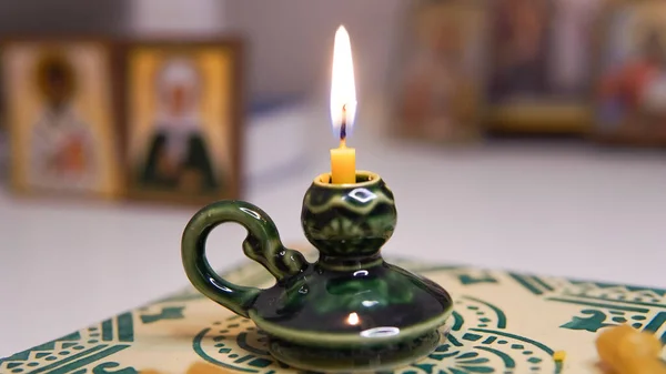 Church candle in green candlestick near icons ,orthodox faith . High quality photo