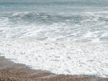 Dalgalı mavi deniz ve kumlu sahil, güzel doğal deniz manzarası, duvar kağıdı ve arka plan kopyalama alanı