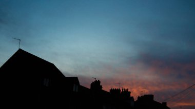 Gün batımında mavi ve turuncu gökyüzü arka planında evler. Boşluğu kopyala