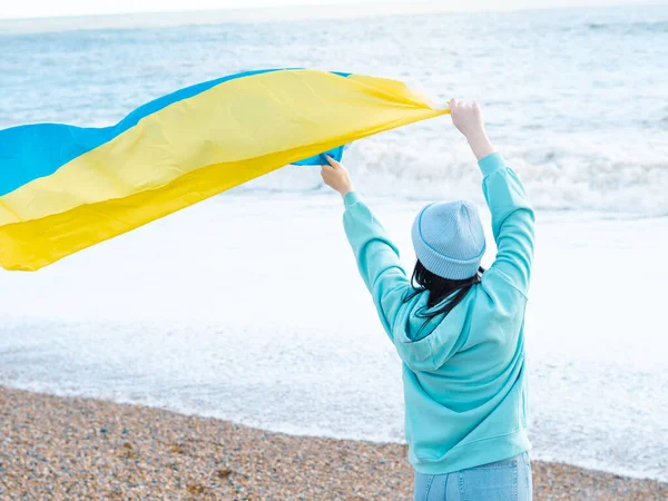 Stock image brunnete woman wearing in blue hoodie and blue hat with national flag of Ukraine,patriotic concept