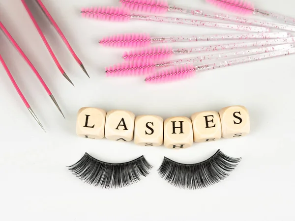 stock image inscriptions lashes on wooden beads,beauty salon treatment concept.lash extensions